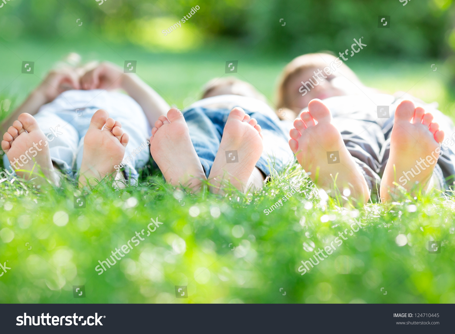 Group Of Happy Children Lying On Green Grass In Spring Park Stock Photo ...