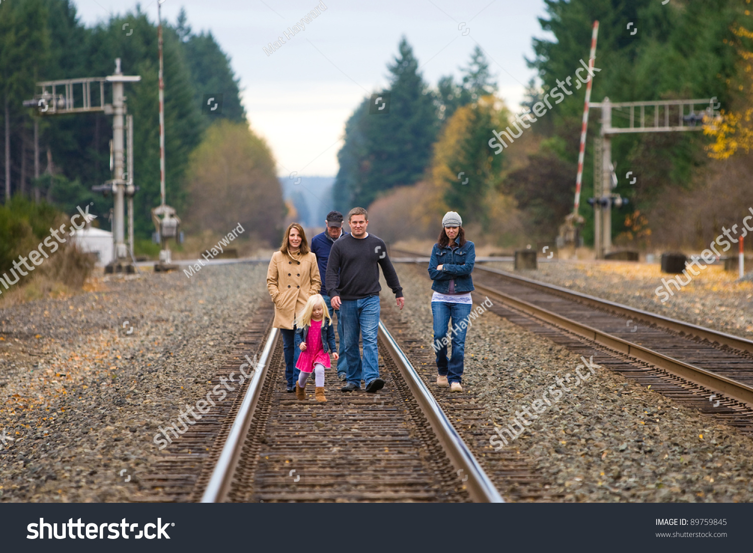 Group Of People Walking Down Train Tracks Outside On An Autumn Day ...