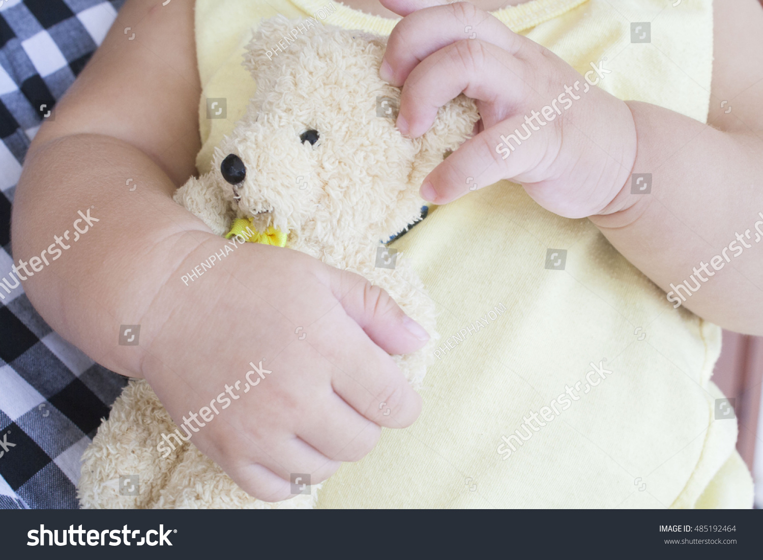 baby holding teddy bear