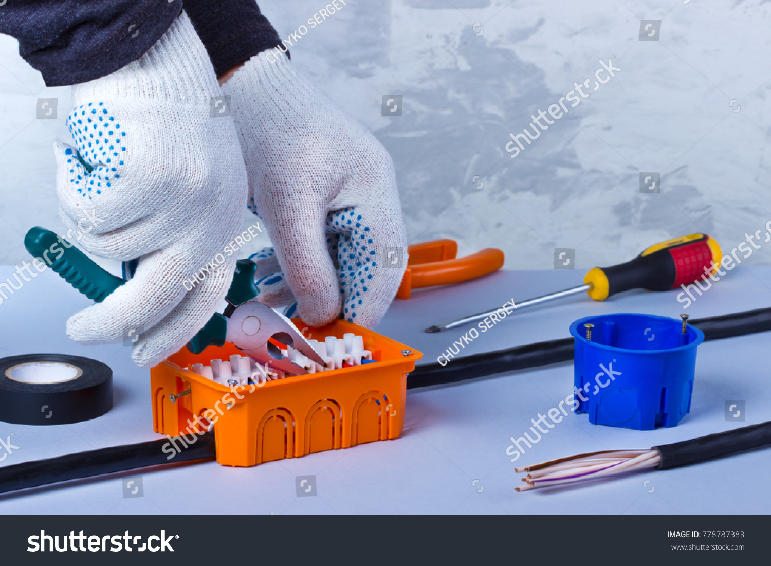 Hands of electrician with pliers repair equipment in fuse box
