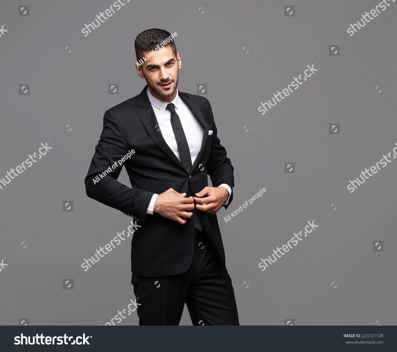 Handsome Hispanic Elegant  Man  In Black  Suit On Grey 