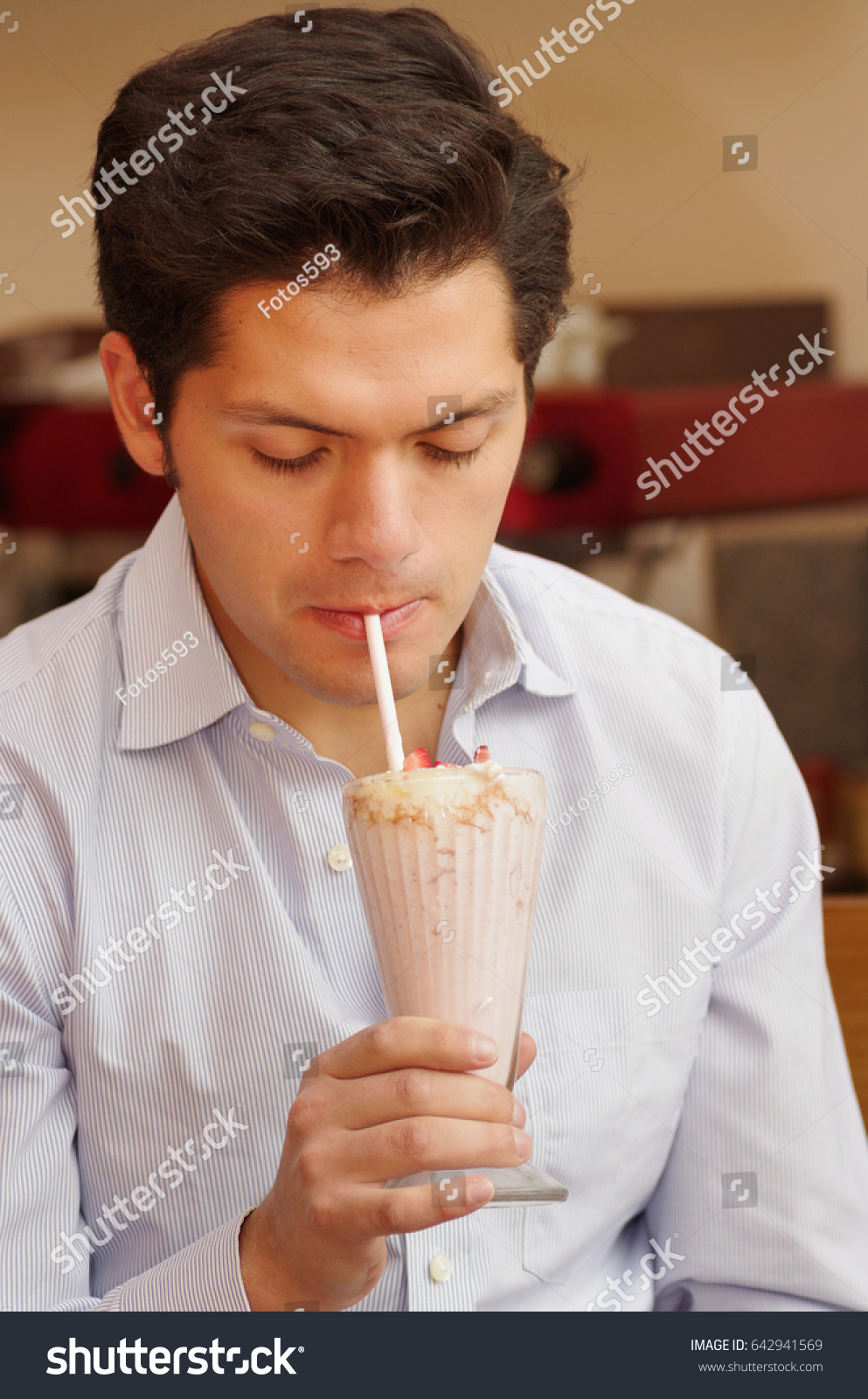 stock-photo-handsome-man-having-a-milkshake-with-a-plastic-straw-642941569.jpg