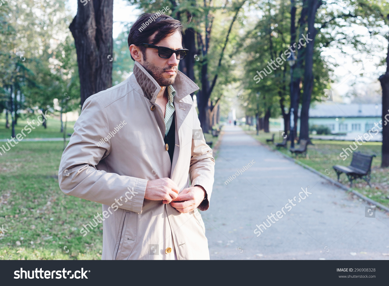 Handsome Man Wearing Trench Coat In Park Stock Photo