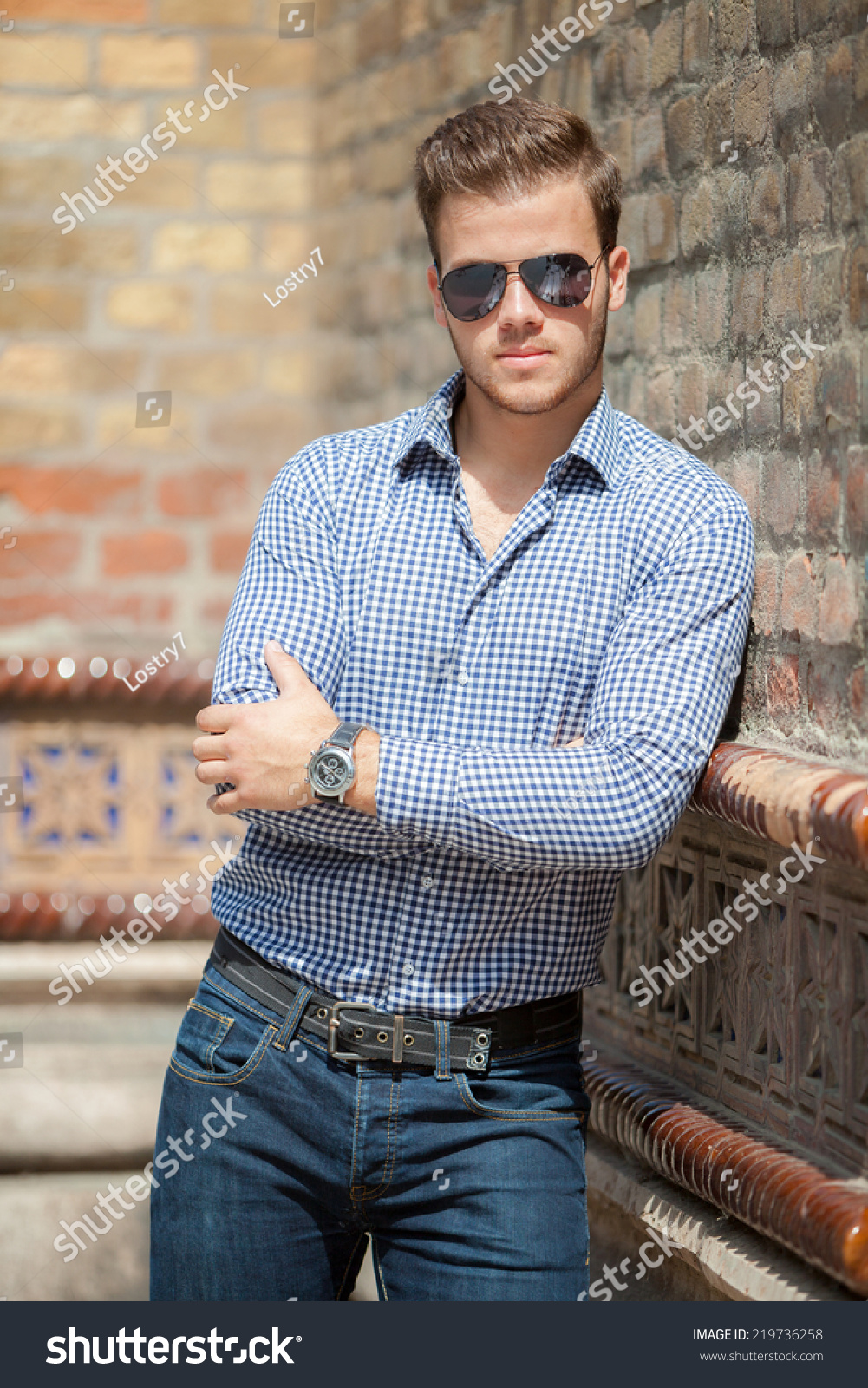 Handsome Young Man Wearing A Blue Shirt And Jeans. Street Shooting In ...