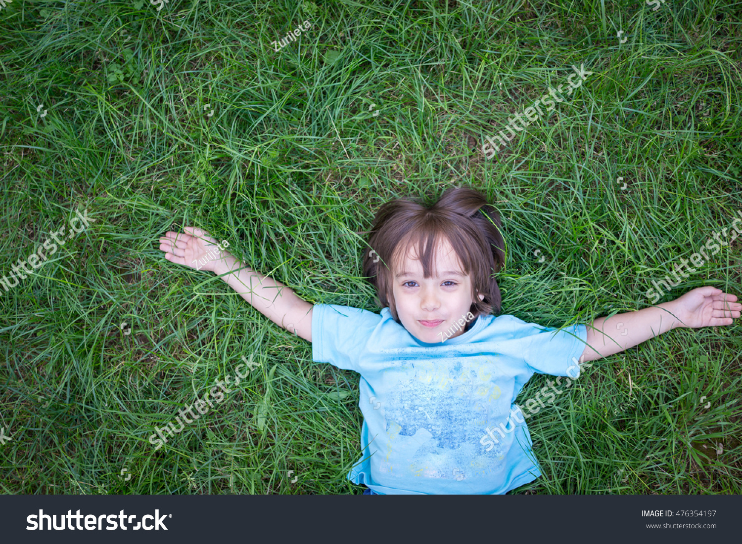 Happy Child Lying On Green Grass Outdoors In Summer Park ...