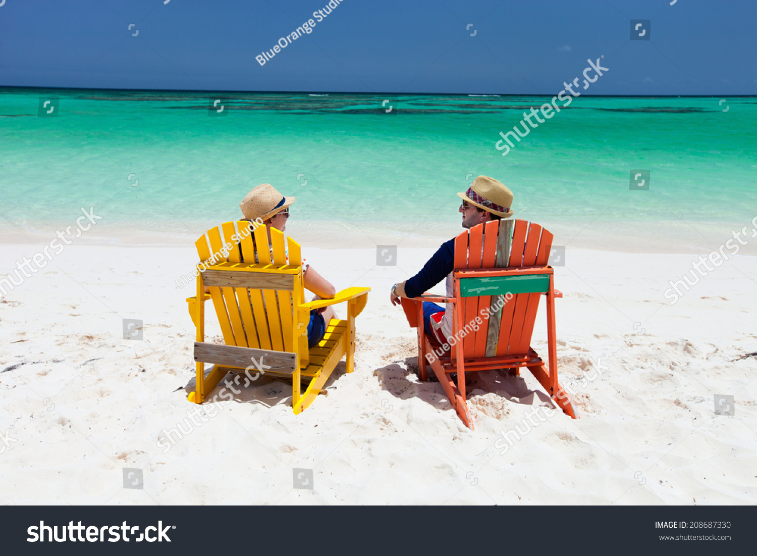 Happy Couple Sitting On Colorful Adirondack Chairs At Tropical Beach Enjoying Caribbean Vacation 9587