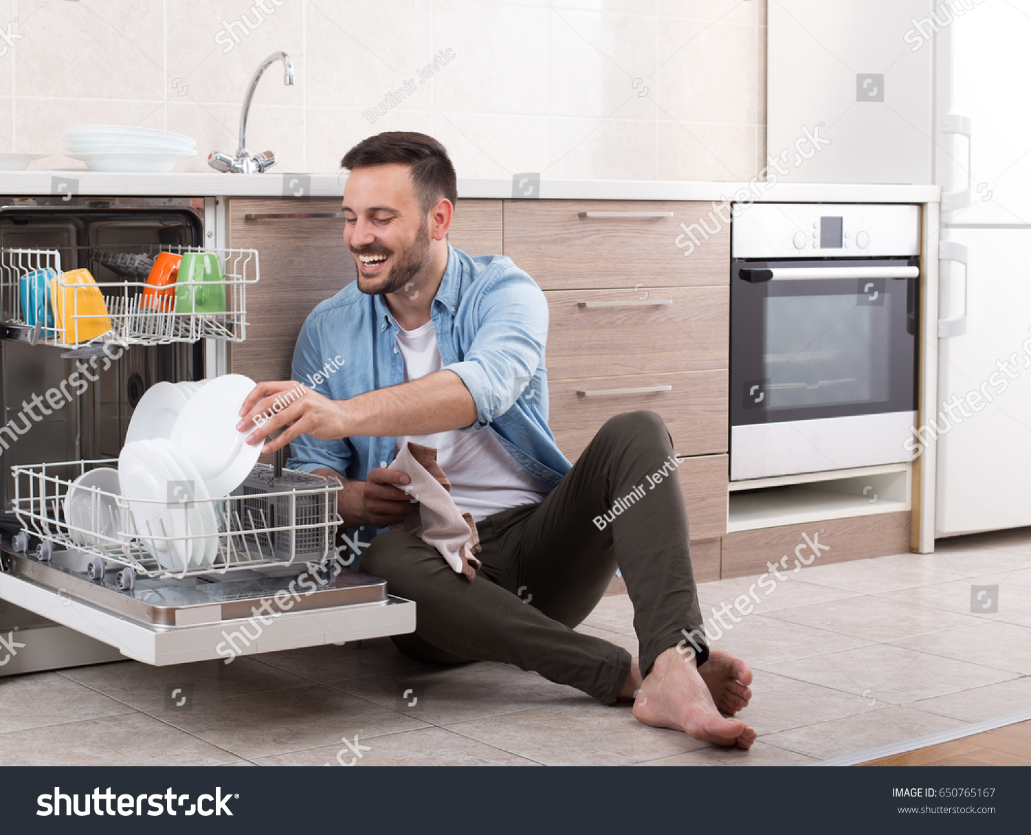 Happy Handsome Man Unloading Dishwasher And Enjoying In Housework Husband Doing Chores Kitchen Happy Handsome Man Unloading Dishwasher And Enjoying In Housework Husband Doing Chores Kitchen