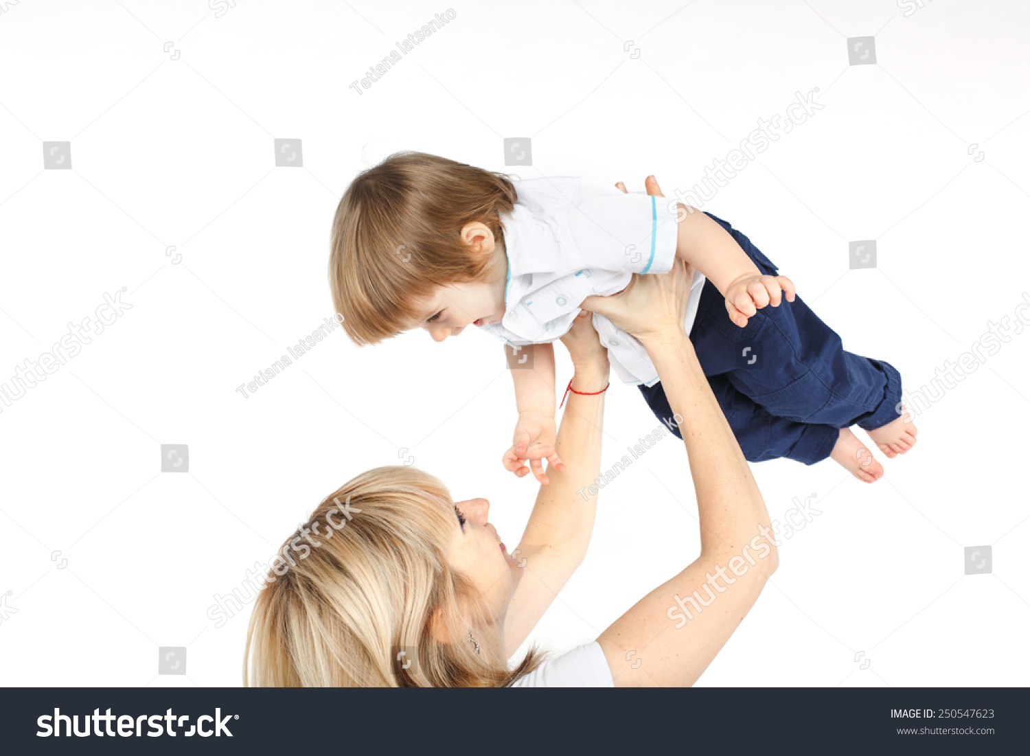 Happy Mother Holding And Lifting Up Her One Year Old Baby Boy Over ...