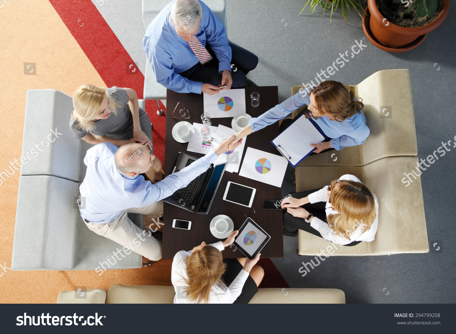 High Angle View Of Business Team Sitting Around The Desk And Shaking ...