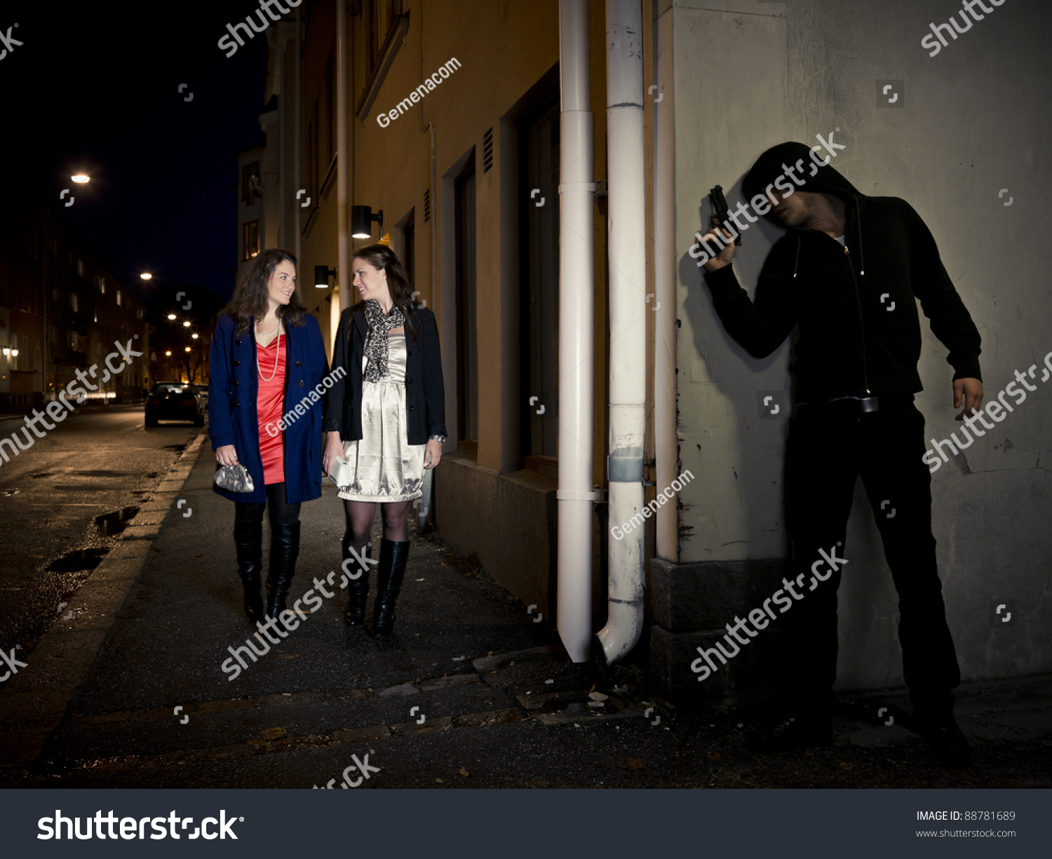 Hooded Man Stalking Two Women Behind A Corner Holding A Gun Stock Photo ...