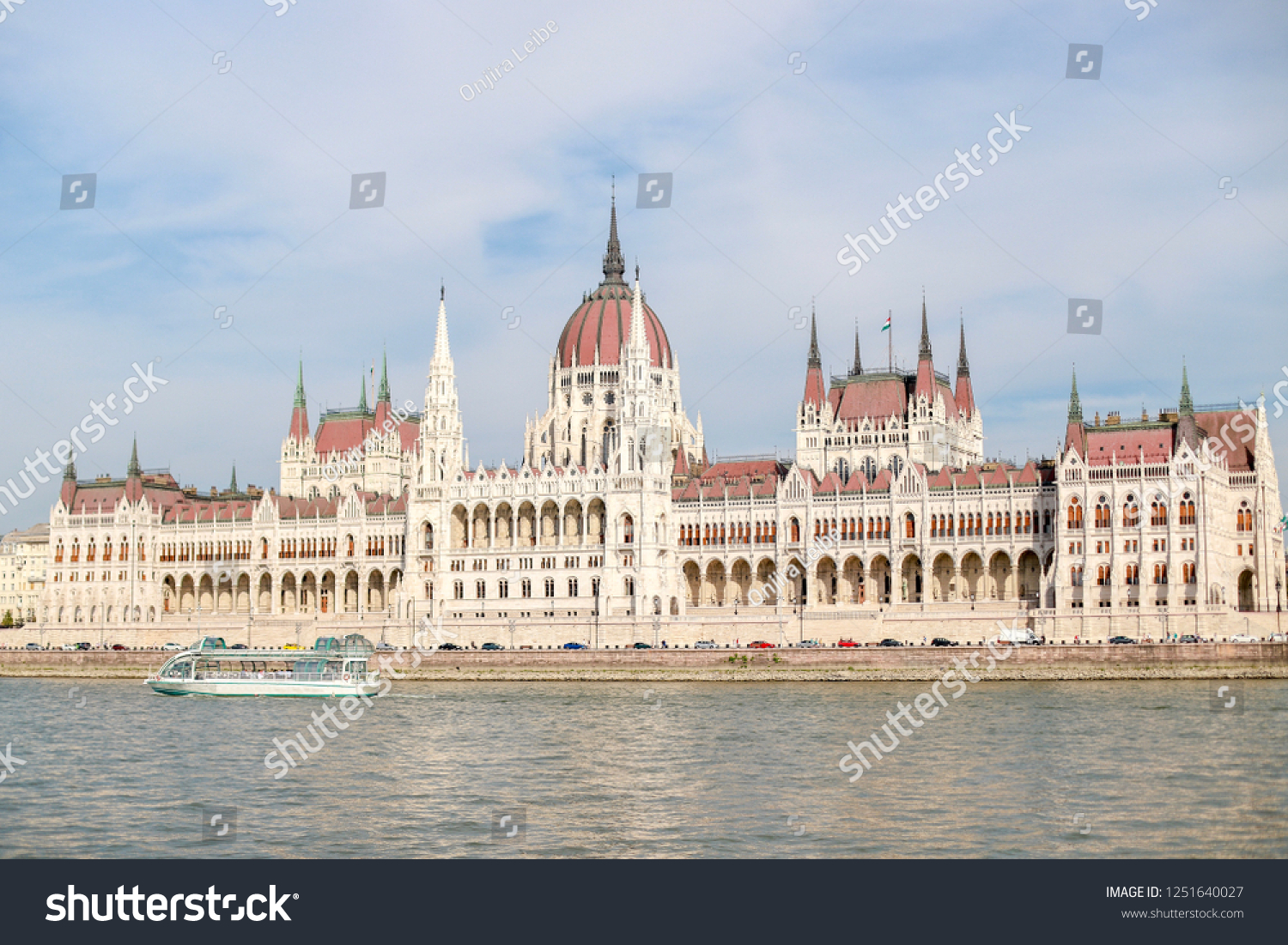 Hungarian parliament water front on a sunny day with blue sky and cloud