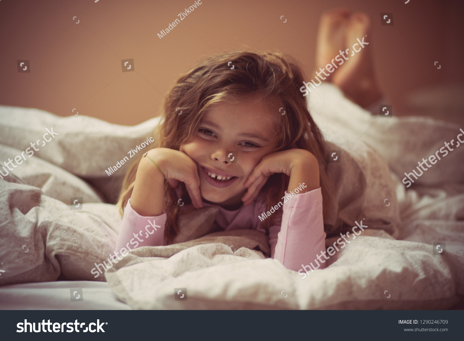 I am like little princess little girl lying on bed looking at camera