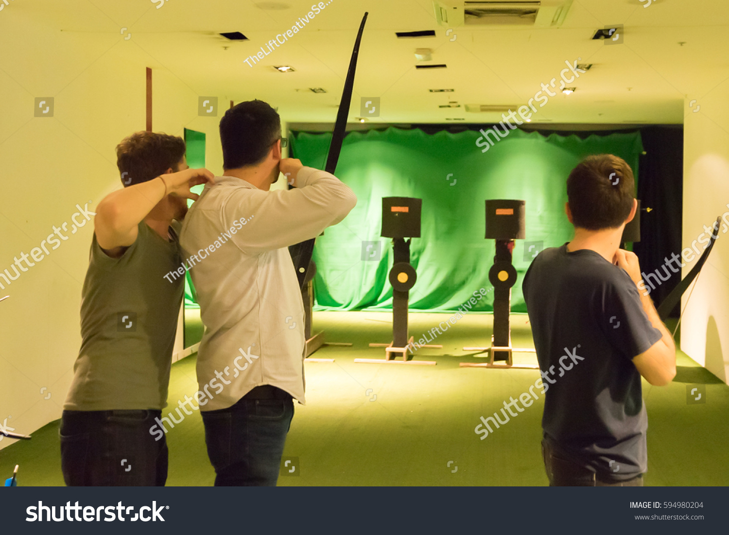 Indoor Archery Range Instructor Guiding Man Stock Photo Edit Now