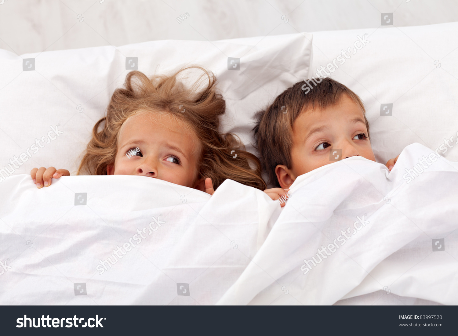 Kids Afraid Laying In Bed And Pulling The Quilt On Their Heads Stock ...