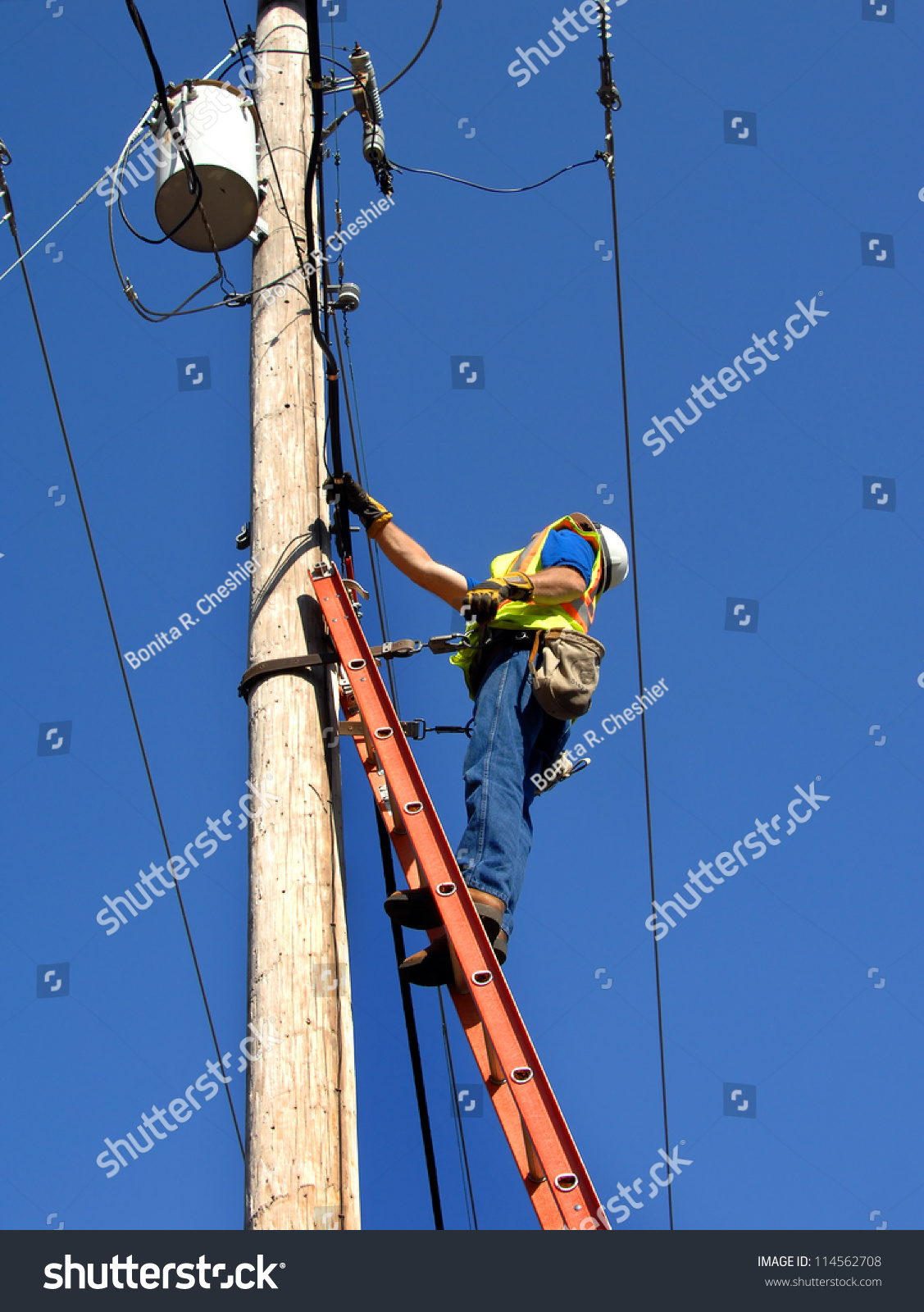 Lineman Climbs Utility Pole To Fix Problem. He Is Standing On A Ladder ...