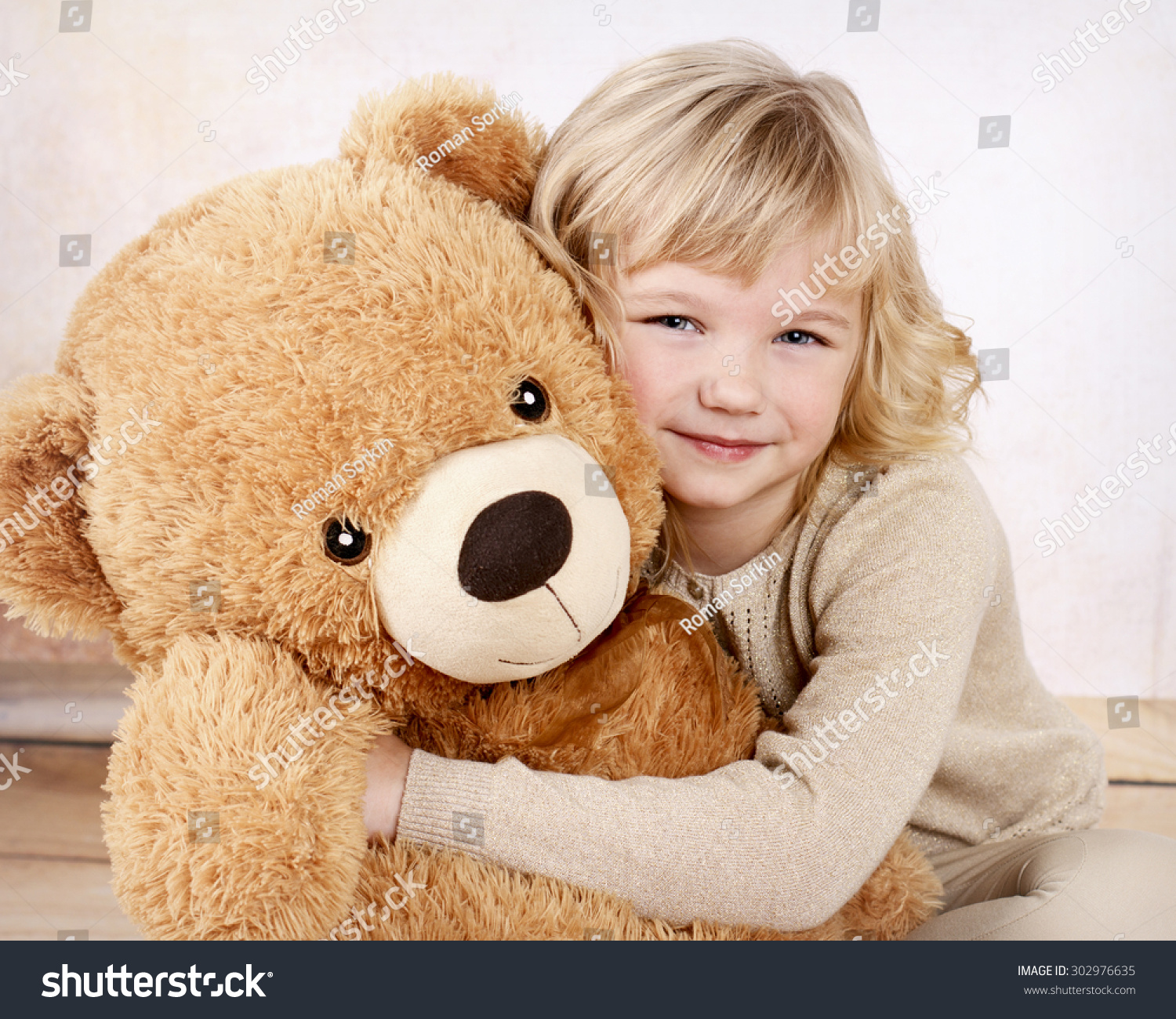 girl cuddling with giant teddy bear