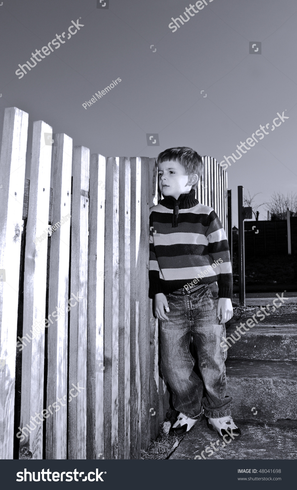 Lonely Boy Stands By A Fence. Stock Photo 48041698 : Shutterstock