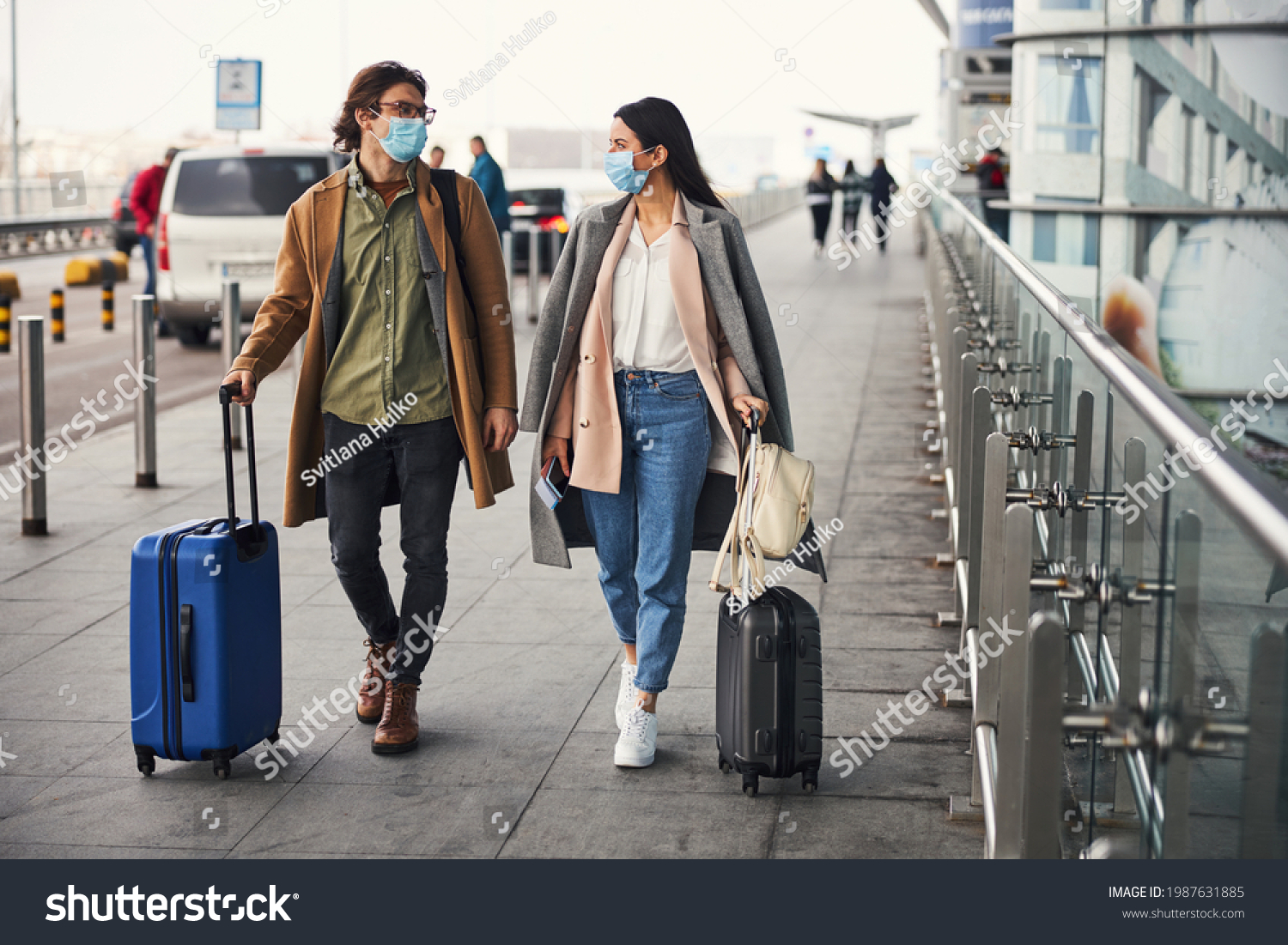 Stock Photo Lovely Couple In Medical Masks Walking Outdoors At Airport 1987631885 