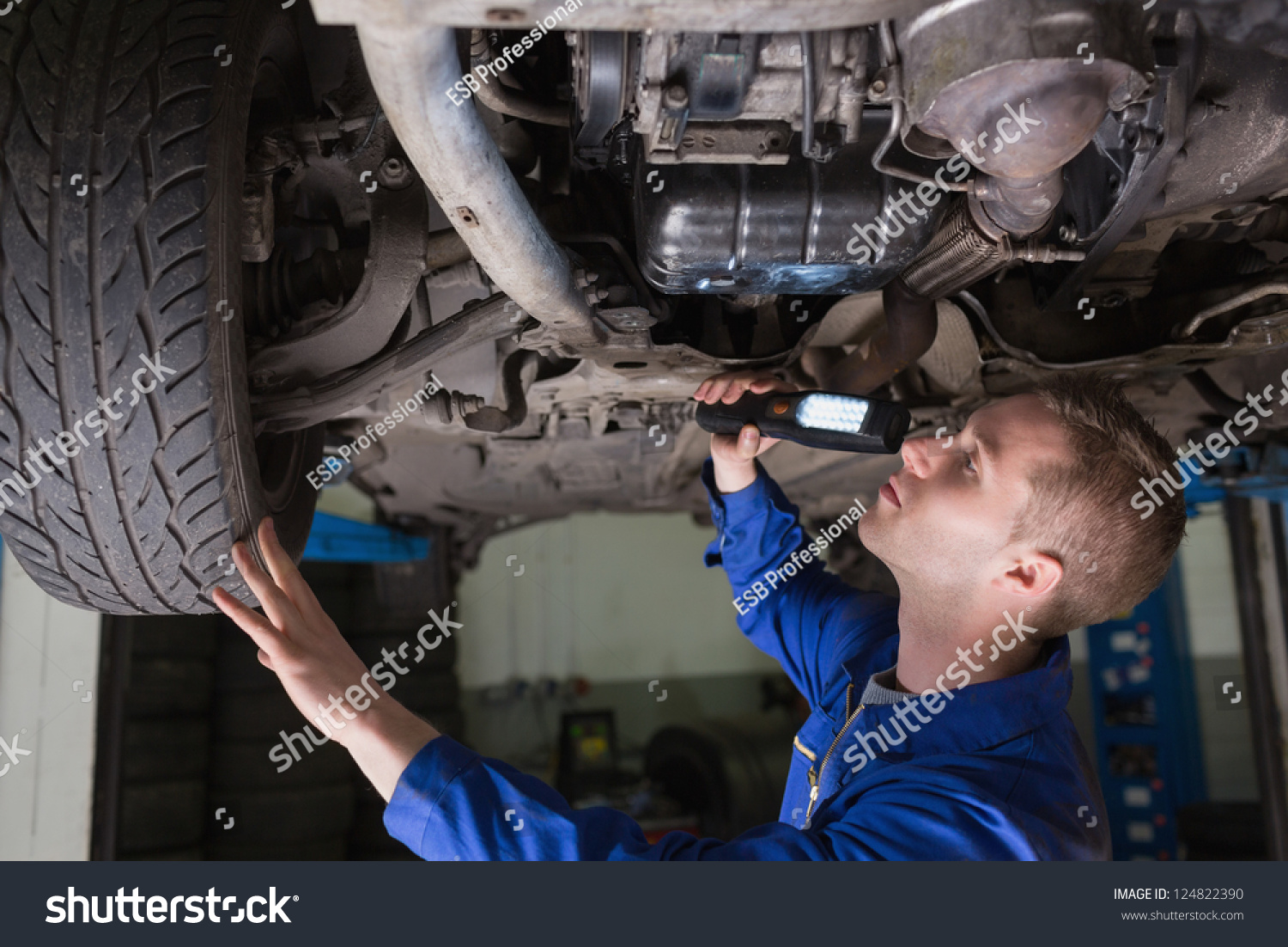 Male Mechanic Examining Car Using Flashlight Stock Photo (Edit Now ...