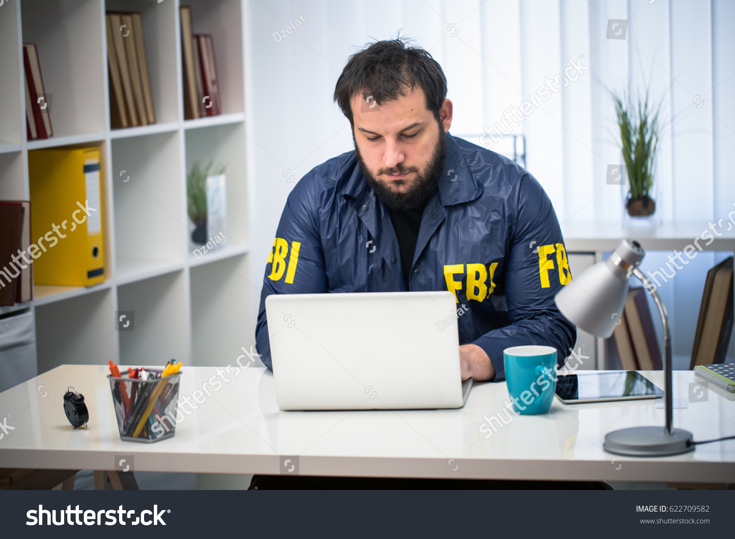 stock-photo-man-fbi-agent-working-in-his-office-on-computer-alone-622709582.jpg