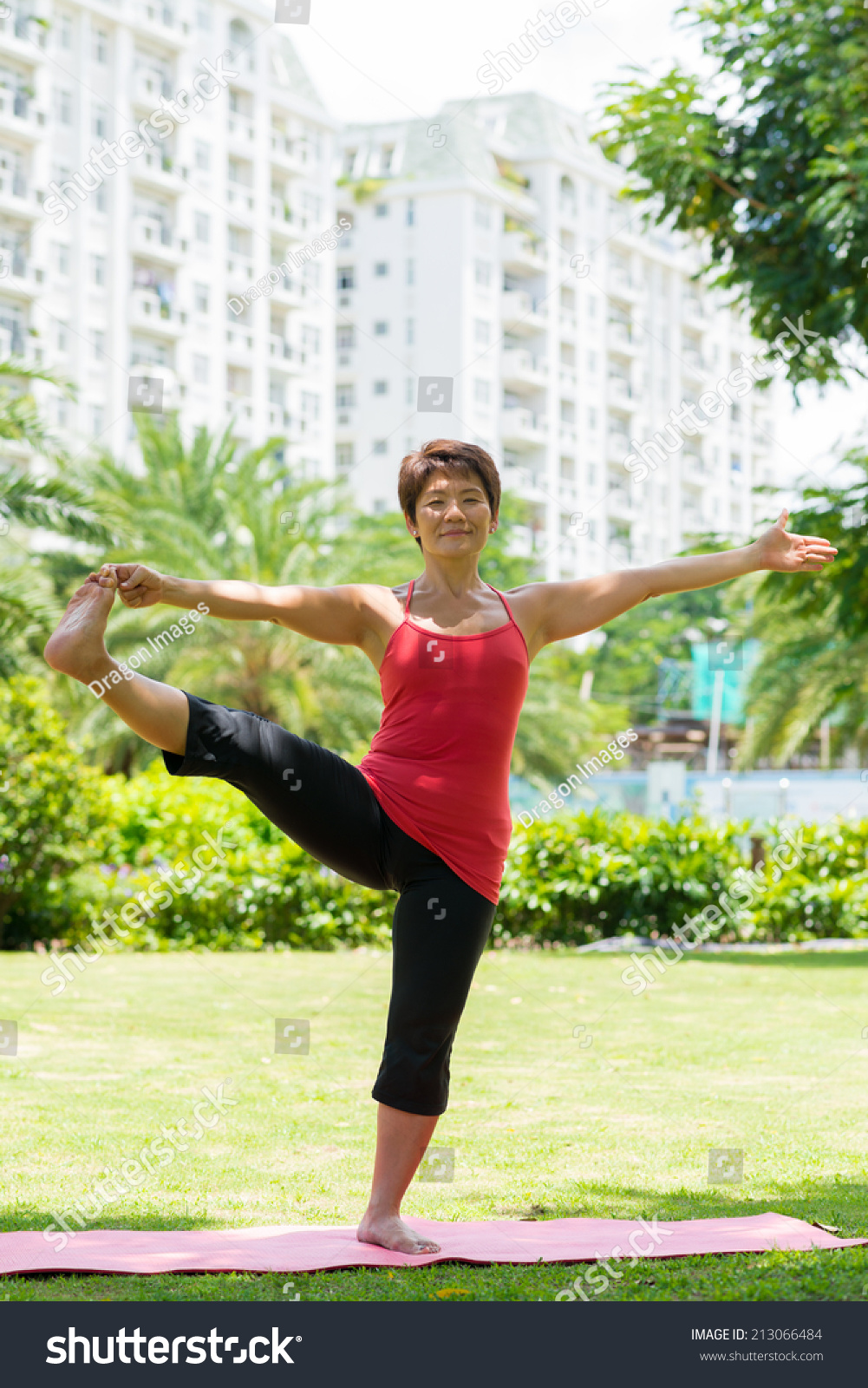 Mature Asian Woman Doing Stretching Exercise For Her Legs In The Park Mature Asian Woman Doing Stretching Exercise For Her Legs In The Park