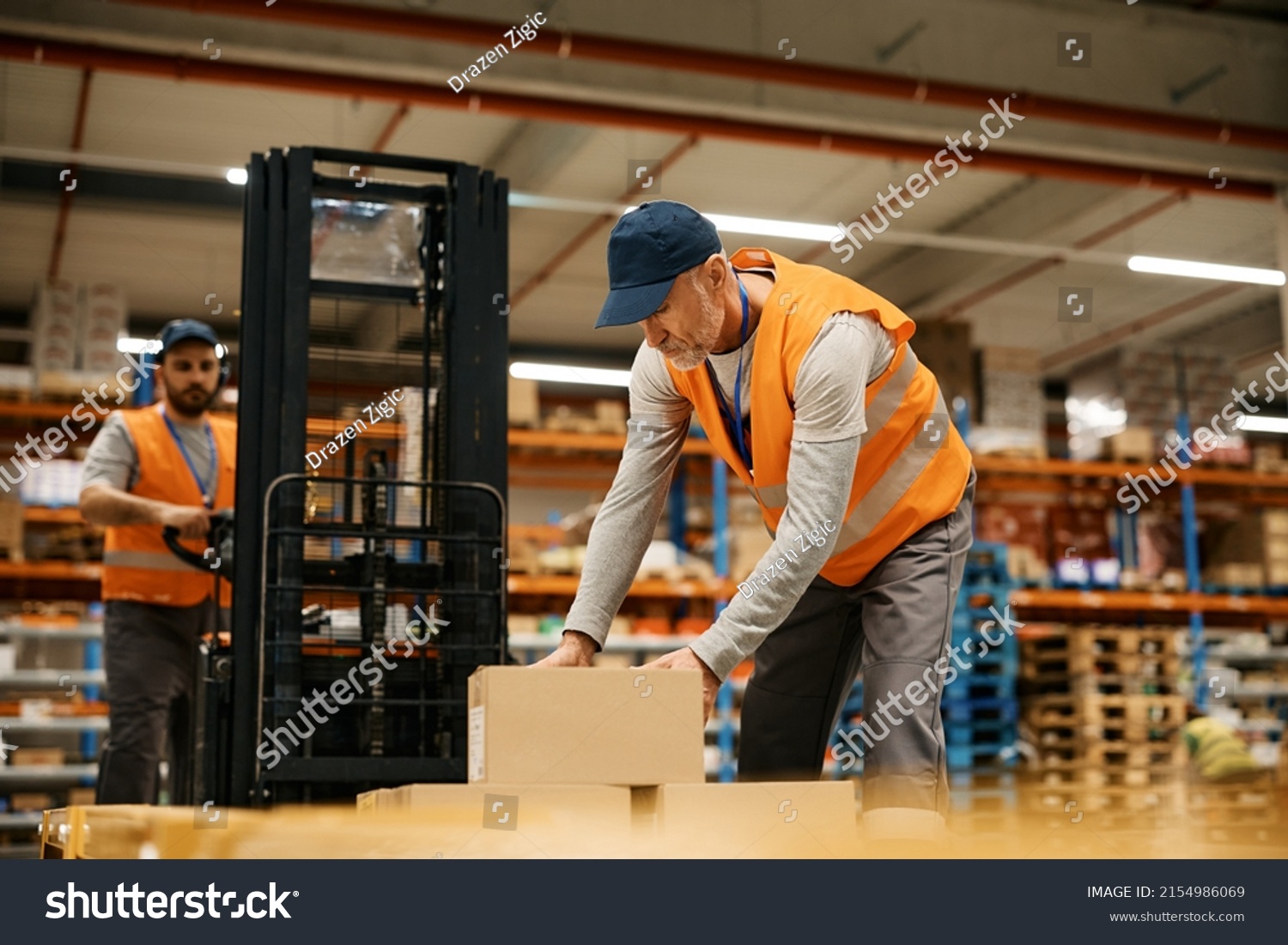 Mature Warehouse Worker Organizing Shipment Boxes Stock Photo ...