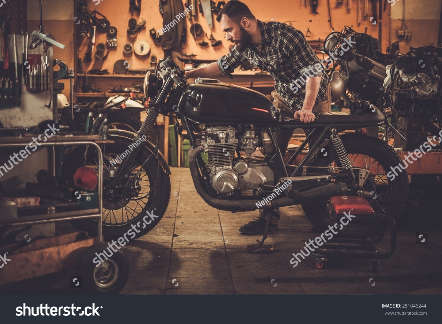 Mechanic building vintage style caferacer motorcycle stock photo ...