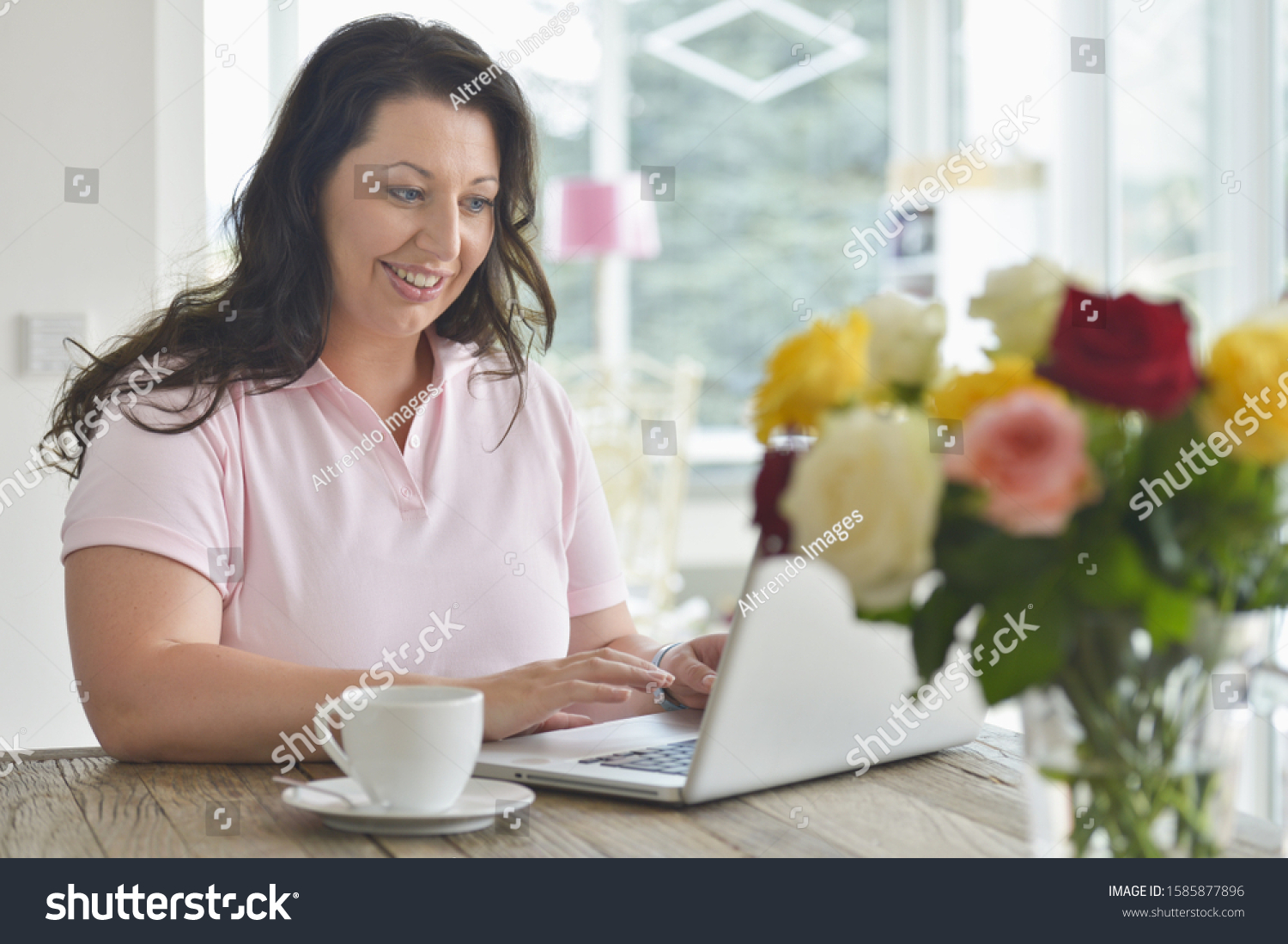 Mid adult woman using laptop at home