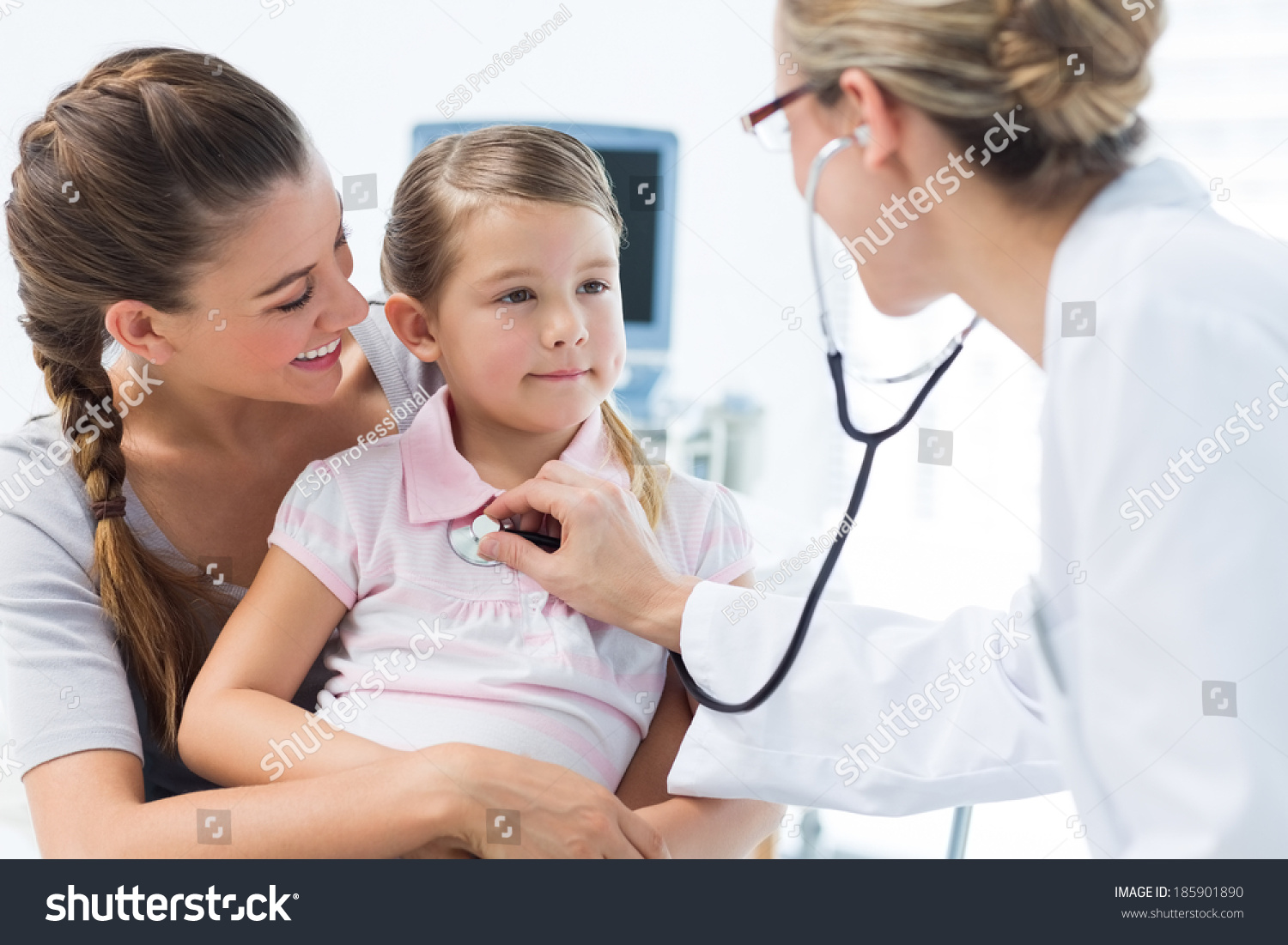 Mother with girl being examined by female pediatrician in clinic