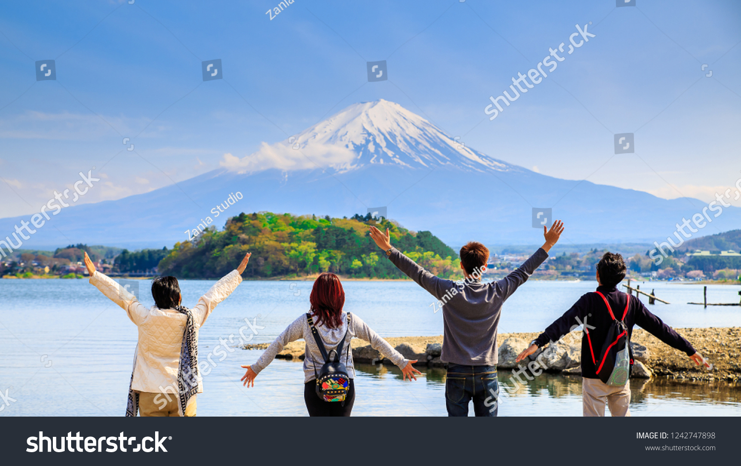 日本の河口湖湖の遊歩道に沿って ダイヤモンド富士山と雪と花の庭が並び 富士山は日本でも有名な場所の一つです 人々は手を挙げて遠くを見る の写真素材 今すぐ編集