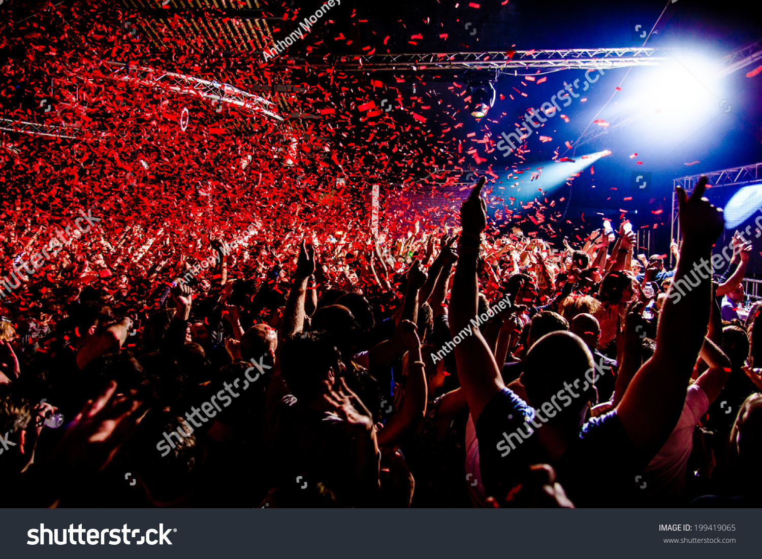 Nightclub party clubbers with hands in air and red confetti