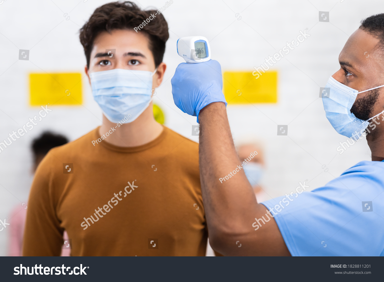 nurse-doing-temperature-screening-asian-man-stock-photo-1828811201