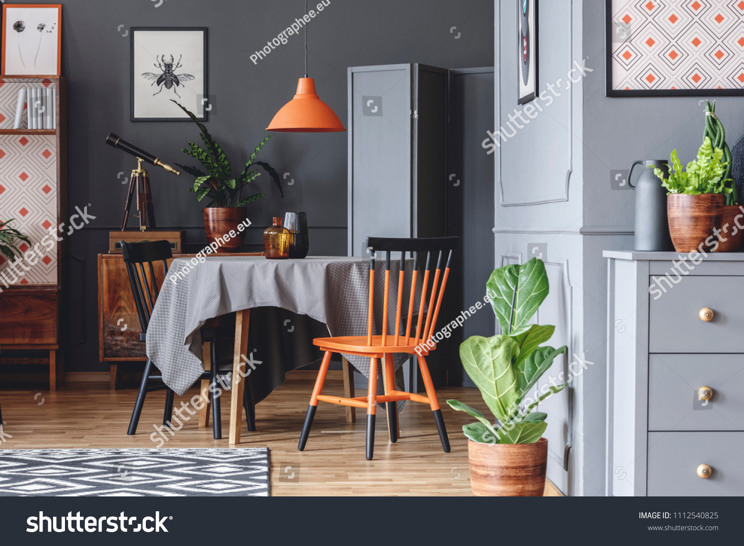 Old Fashioned Dining Room Interior With A Table Chairs Orange Lamp And Plants