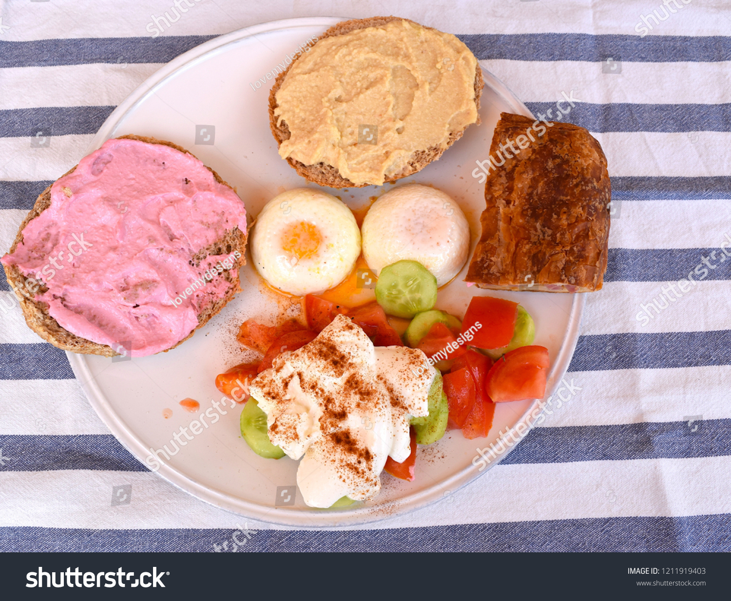 Paphos Cyprus August 11 18 Sandwiches With Taramasalata Humous With The Salad Topped With Yoghurt And Pouched Eggs On A White Plate And Striped Table Cloth On The Background