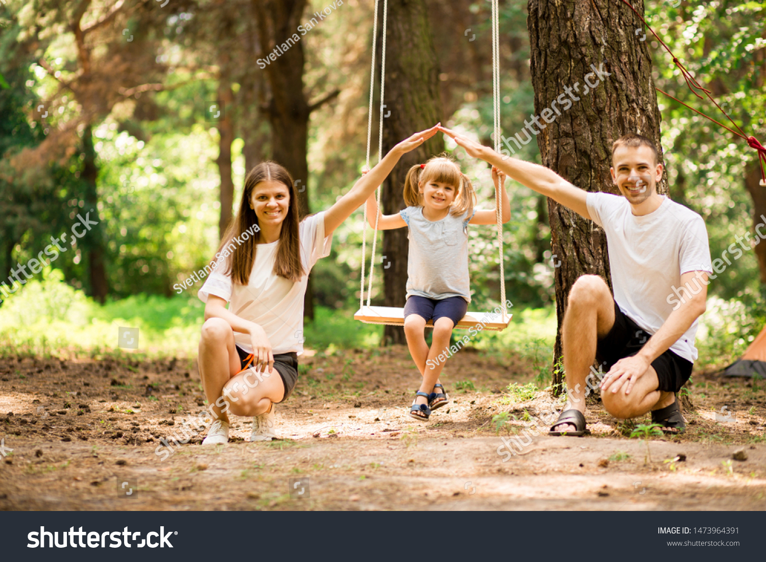 Parents Pushing Children On Swing Garden Stock Photo Edit Now