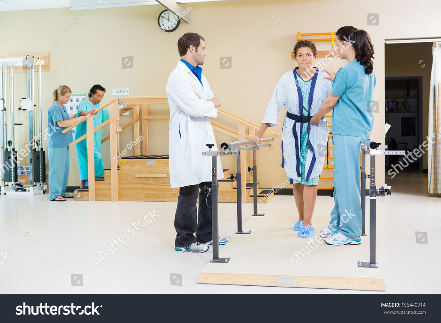 Physical Therapists Assisting Female Patient Walking Stock Photo ...