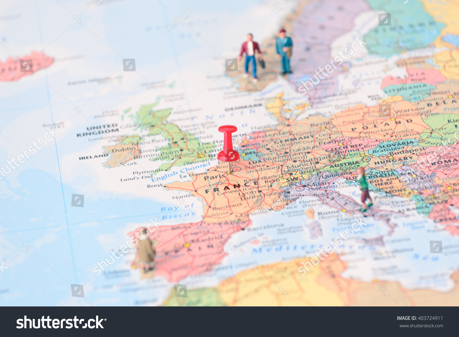 pinned on map of paris in france and miniature travelers