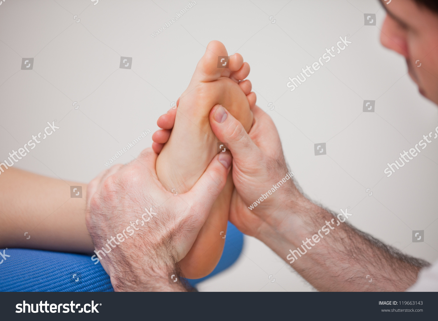 Podiatrist Practicing Reflexology On Foot Woman Stock