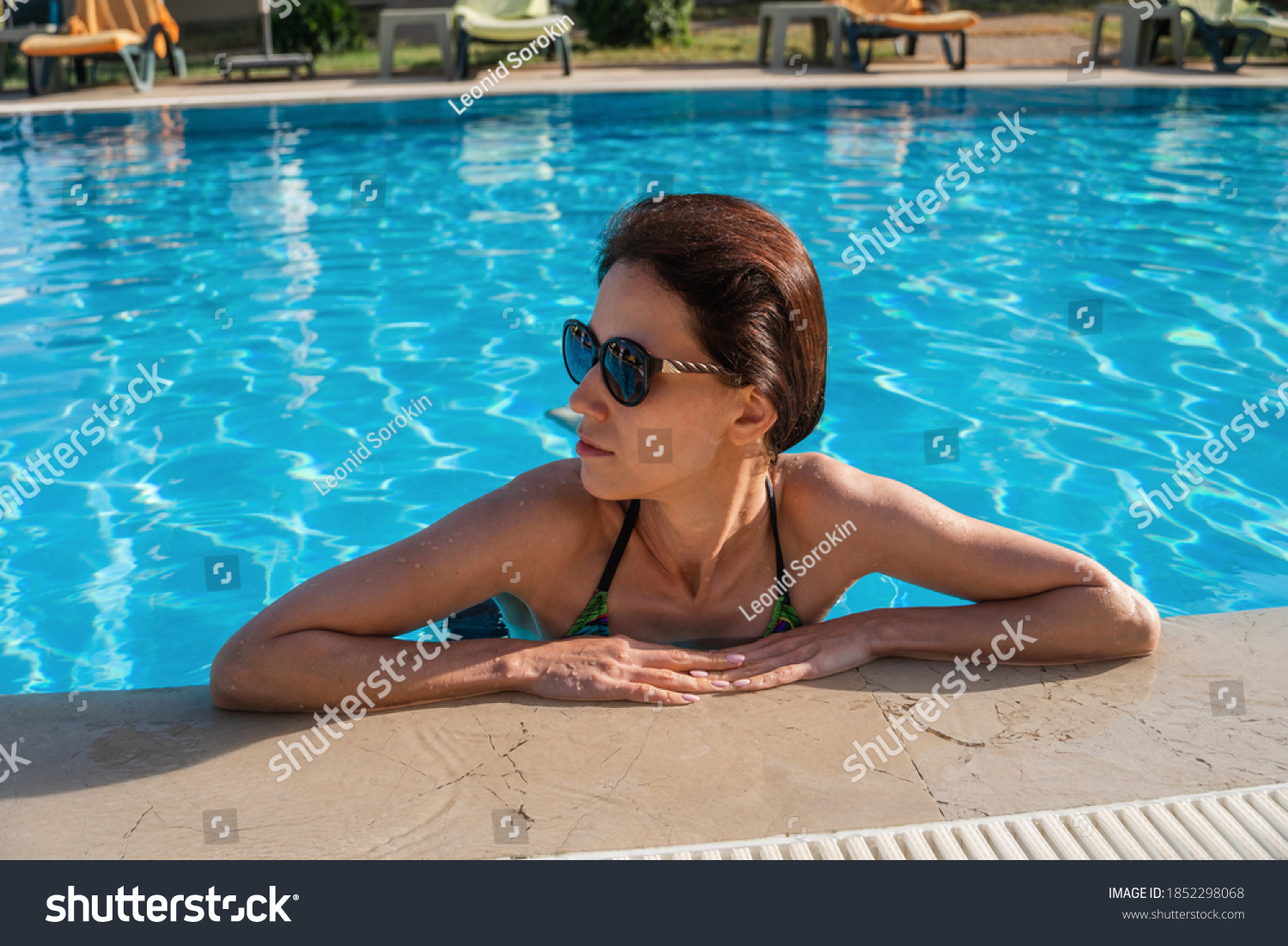 Asian woman pouring nude body with water before the pool
