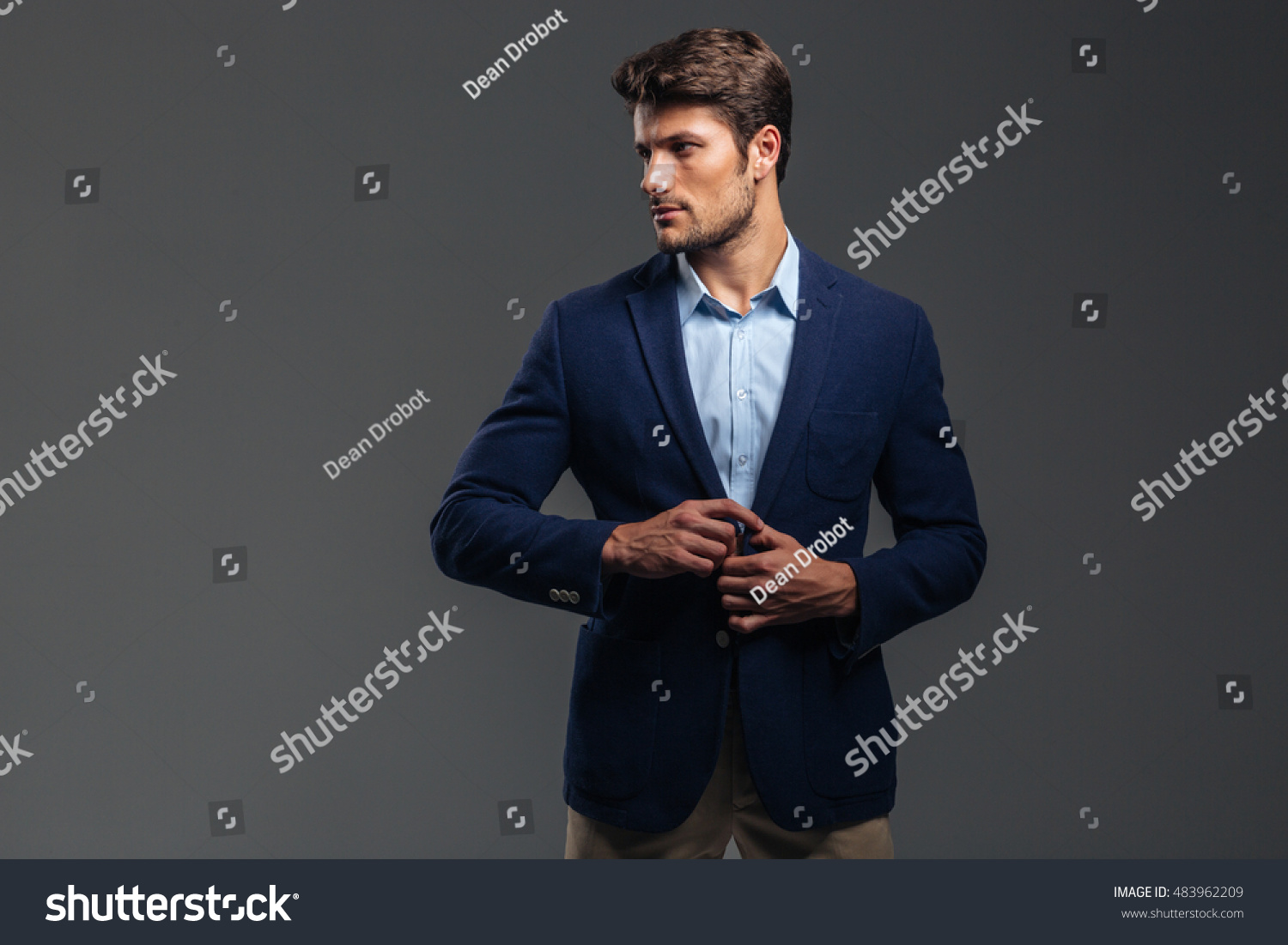 Portrait Of A Casual Handsome Man Buttoning His Jacket Isolated On A