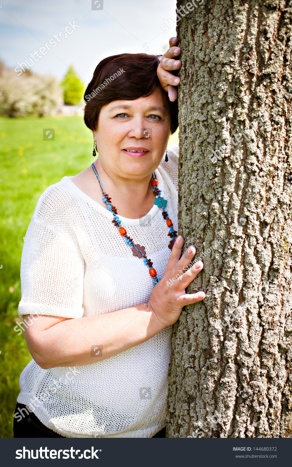 Portrait Of A Happy Old Woman Holding A Tree In Outdoor Background ...