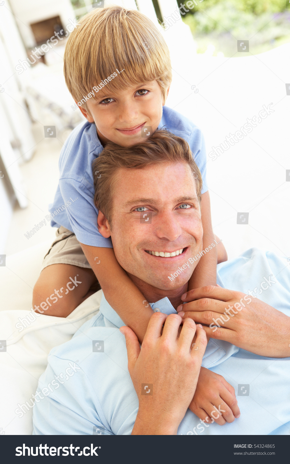 Portrait Of Father And Son Relaxing On Sofa Stock Photo 54324865 ...