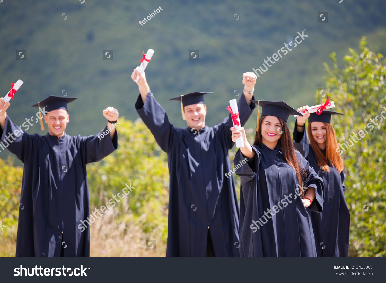 Portrait Happy Students Graduation Gowns Holding Stock Photo 213435085