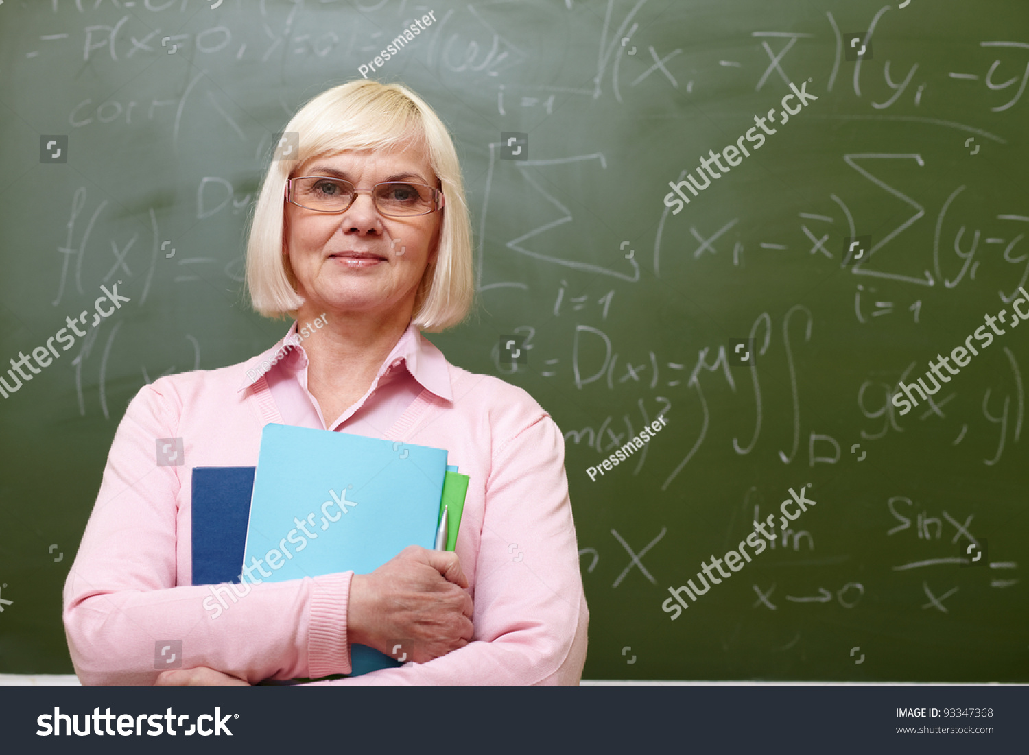 Portrait Of Mature Teacher With Copybooks Looking At Camera With ...