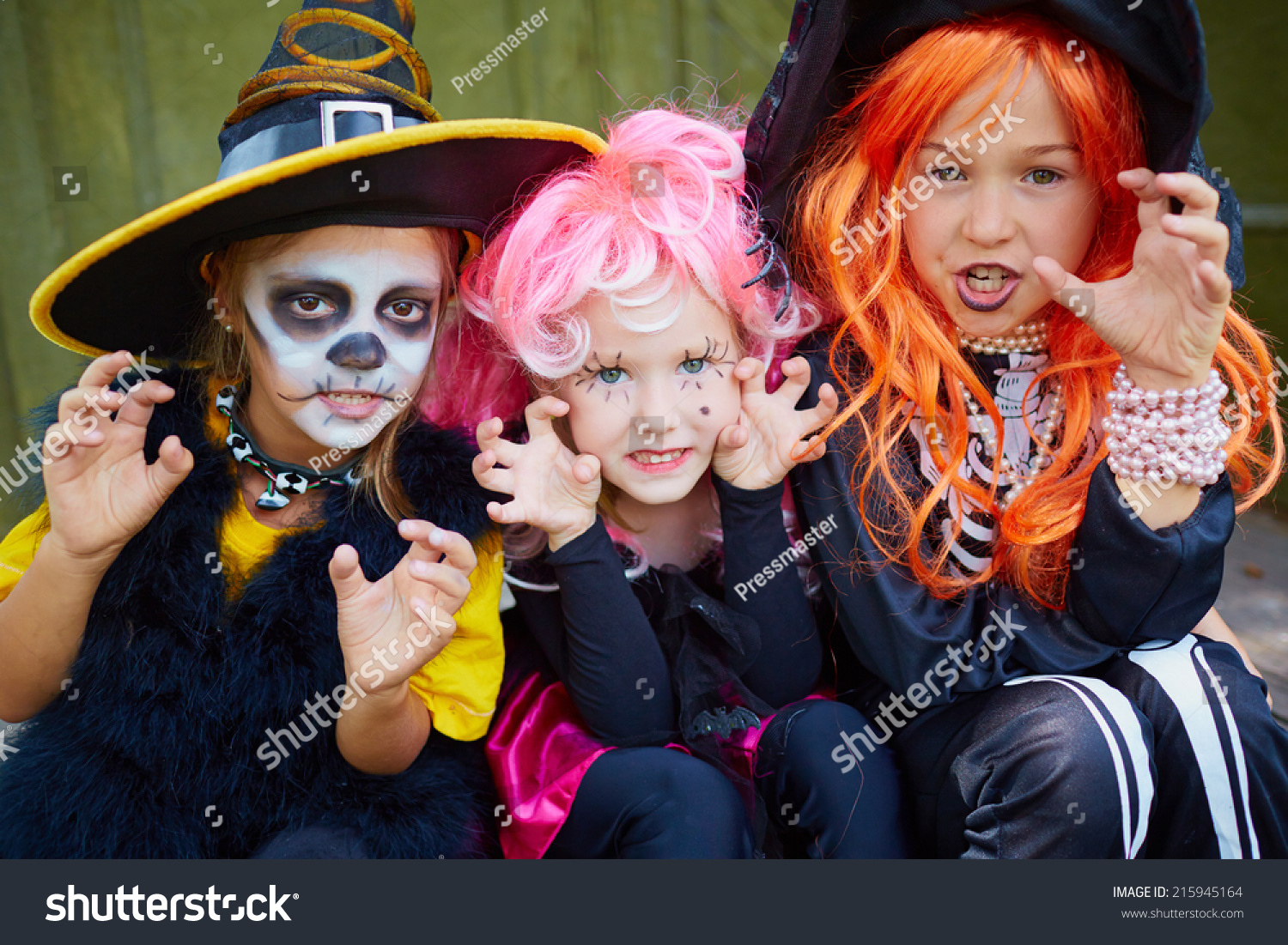 portrait of three little girls in halloween costumes looking at camera with frightening gesture - Halloween Costumes Three Girls portrait of three little girls in halloween costumes looking at camera with frightening gesture - Halloween Costumes Three Girls