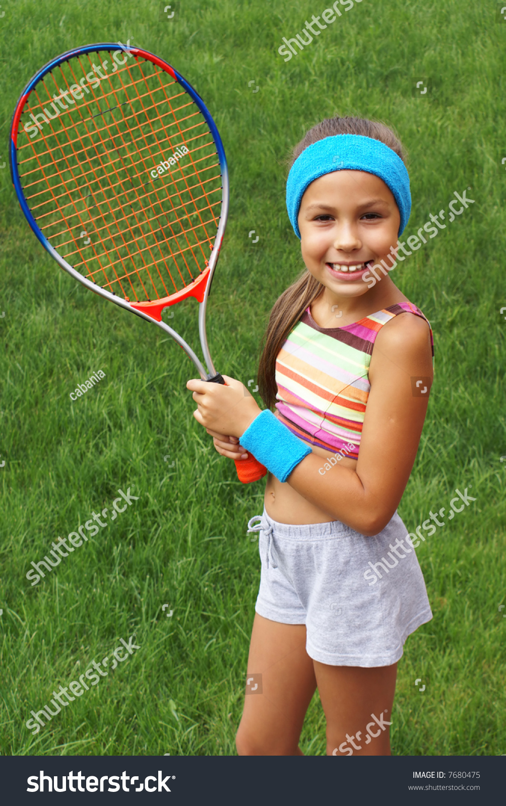 Preteen Girl Playing Tennis Outdoors On Green Grass 