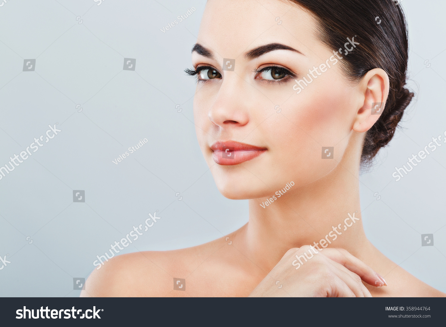 Pretty Girl With Big Eyes And Dark Eyebrows With Naked Shoulders Looking At Camera And Smiling