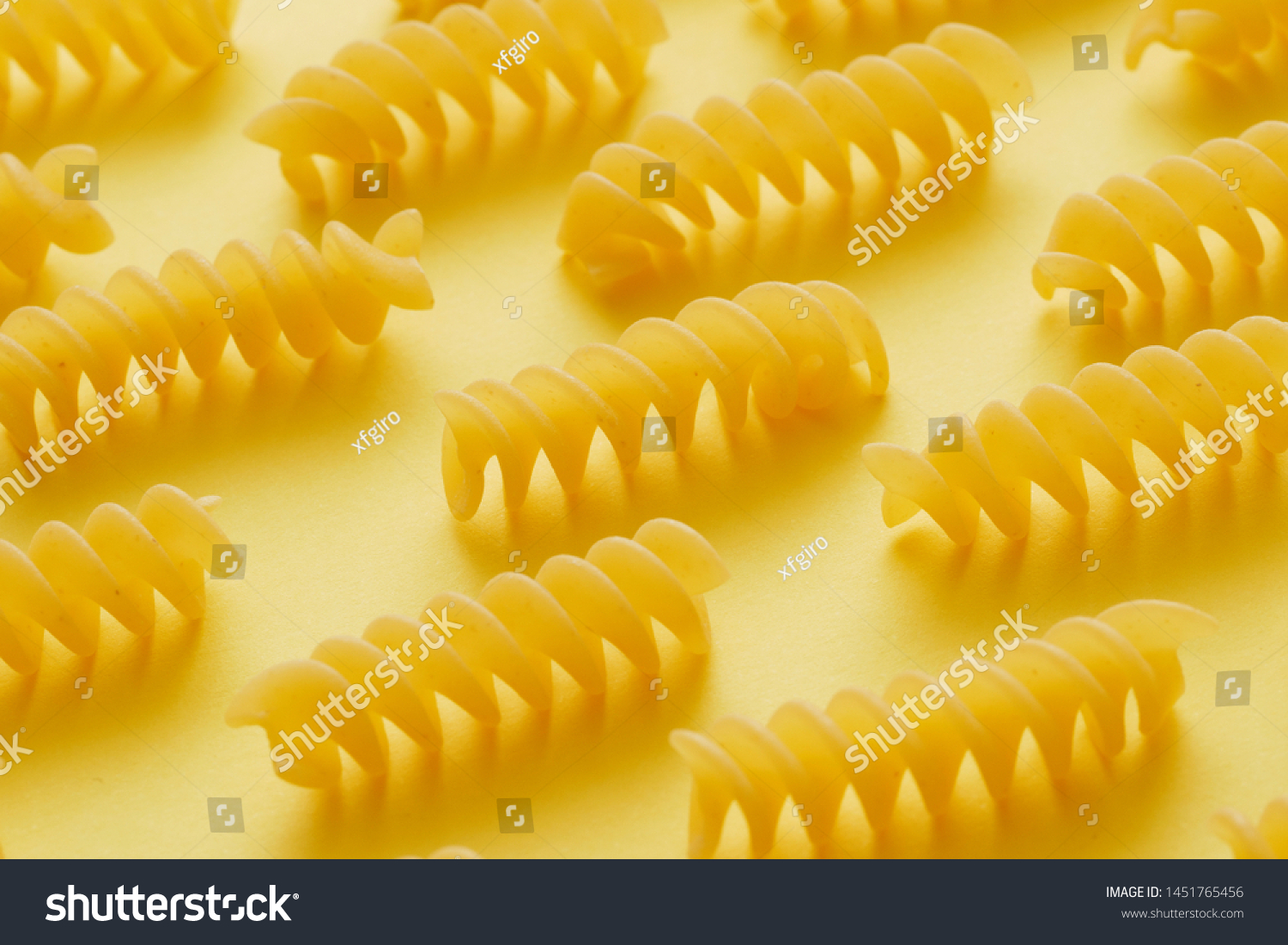 Download Raw Fusilli Pasta Over Yellow Background Stock Photo Edit Now 1451765456 PSD Mockup Templates