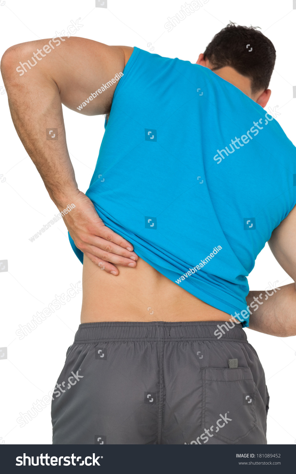 Rear View Of A Young Man In Sportswear Suffering From Backache Over