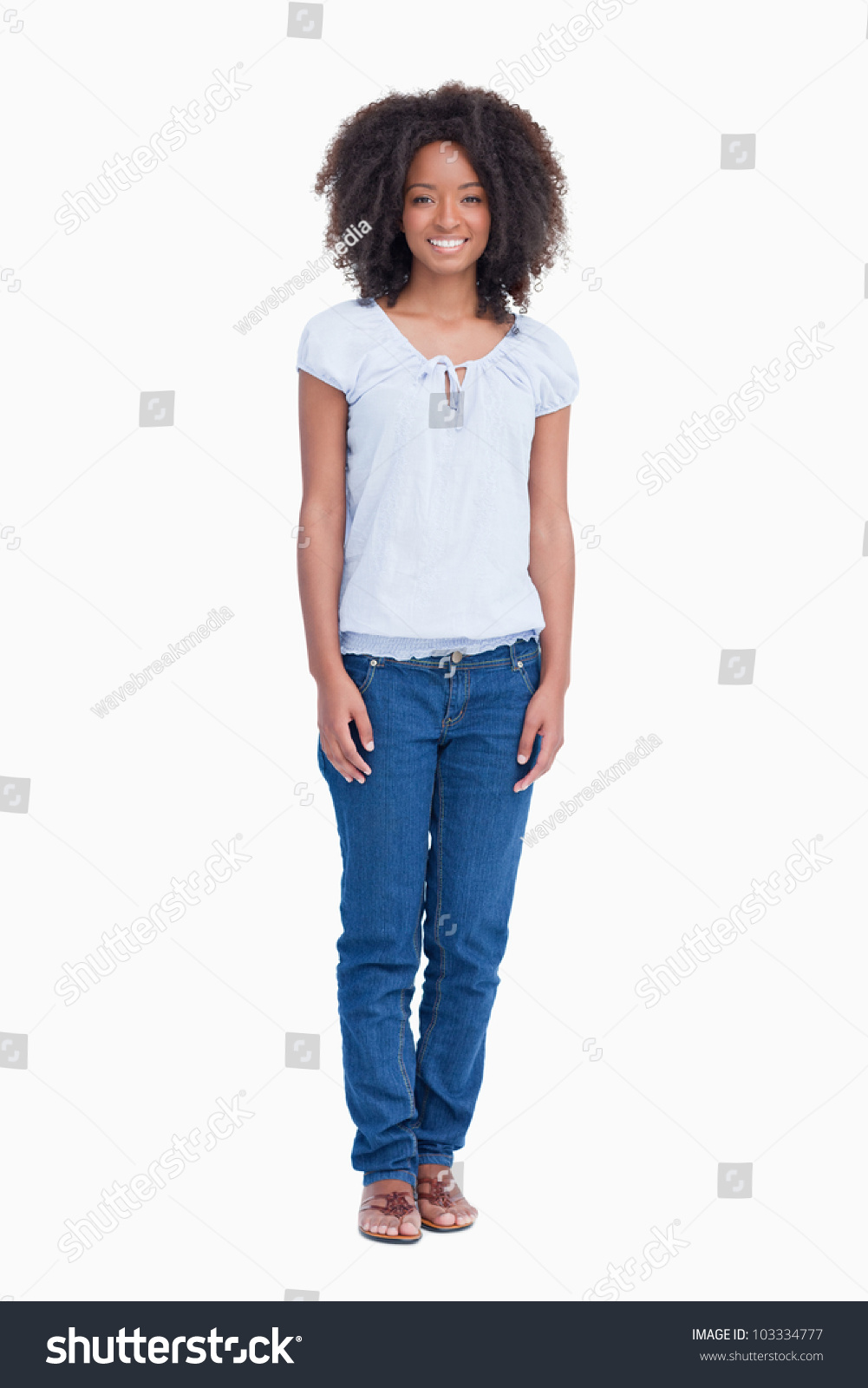 Relaxed Young Woman Standing Up With Arms By Side Against A White ...